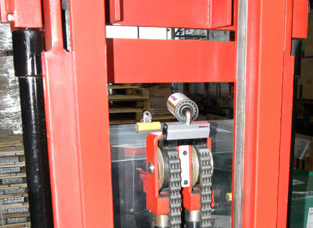 La cadena de una carretilla elevadora se lubrica automáticamente con un lubricador simalube y se limpia simultáneamente con el cepillo.
