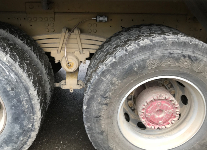 Un graisseur simalube 125ml monté à distance lubrifie automatiquement et en continu la suspension d'un camion via un raccord de tuyau.