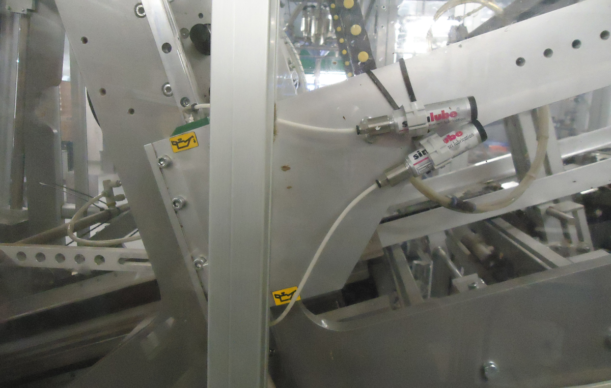 Zwei Stück des kleinsten Schmierstoffgebers der Welt, simalube 15ml, schmieren eine Produktionsmaschine in einem Chemiewerk automatisch und kontinuierlich.