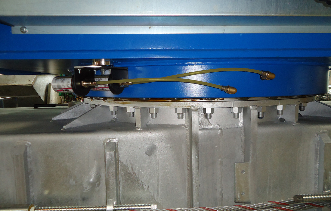Dos lubricadores simalube montados a distancia, conectados con una manguera al punto de lubricación, lubrican la corona de giro de una grúa de construcción.