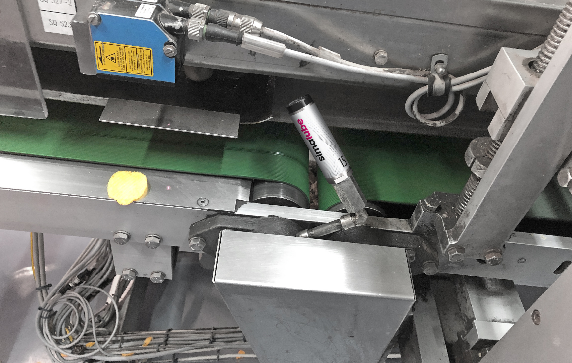 The roller bearing of a drive roller on the conveyor belt is continuously lubricated with simalube.