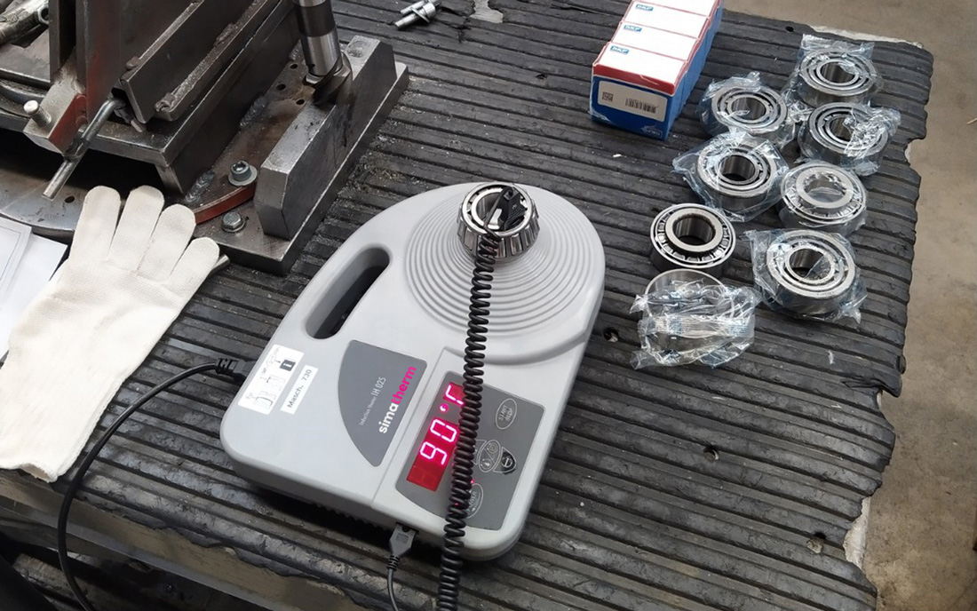 The portable heating device heats a small deep groove ball bearing in the workshop. 