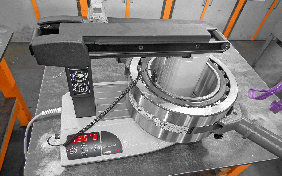 Spherical roller bearings lying over the coil is heated with the simatherm heating device IH 210. The spherical roller bearing is clamped in a simatool Bearing Handling Tool, which enables quick mounting.